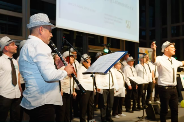 Chor und ein Klarinetten-Spieler, alle tagen weiße Hemden und Hüte sowie schwarze Schlipse (auch die Frauen)