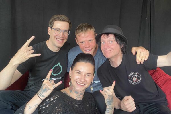 Buntes Foto von vier Menschen: zwei Mitgliedern der Band The Cool Chickpeas zusammenClaudia Lippmann vom Rundfunk-Tanzorchester Ehrenfeld und Vom Ritchie von den Toten Hosen. Alle gucken lächelnd in die Kamera.