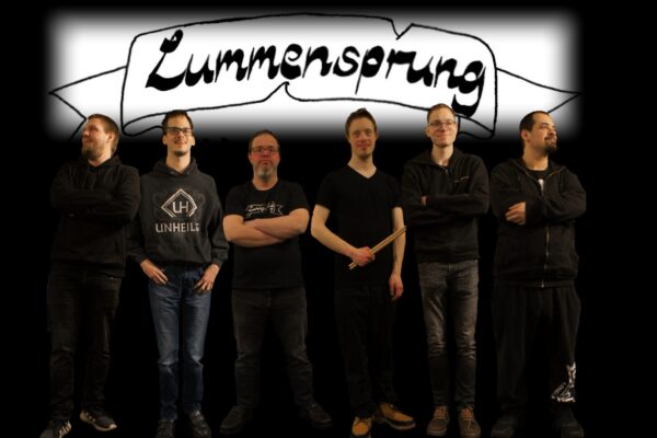 Buntfoto der sechs Mitglieder der Band, stehend und in die Kamera guckend, Kleidung und auch Hintergrund fast völlig in schwarz gehalten. Über der Band ist ein weißes Feld mit schwarzem Schriftzug "Lummensprung". Alle gucken freundlich.